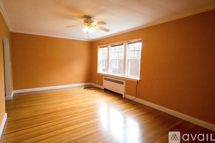 A room with a ceiling fan and a window with blinds.
