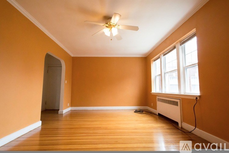 A room with orange walls and a ceiling fan.