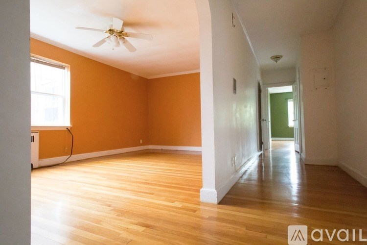 A room with wooden floors and a ceiling fan.