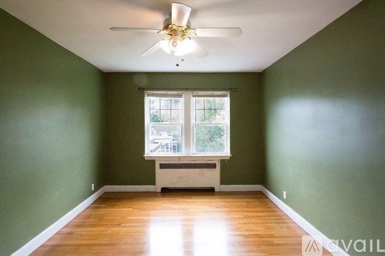 A room with green walls and a ceiling fan.