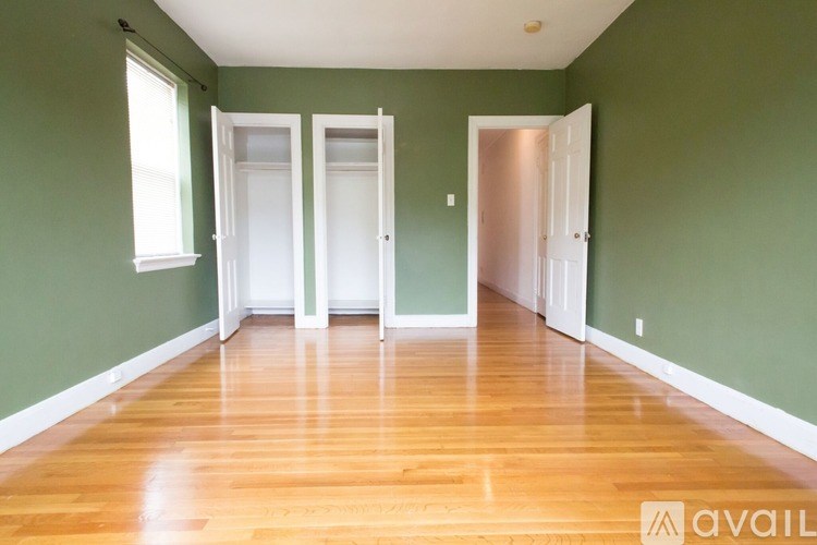 Three white doors are in a room with green walls.
