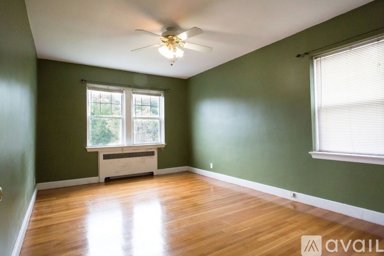 A room with a ceiling fan and a window with blinds.