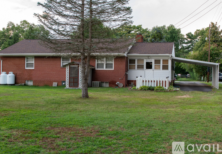A house with a red brick exterior and a white picket fence.