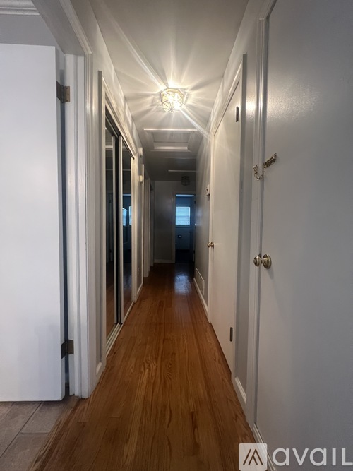 A long hallway with doors on both sides and a light on the ceiling.