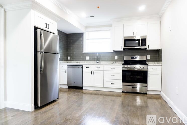 A kitchen with a refrigerator, oven, and microwave.