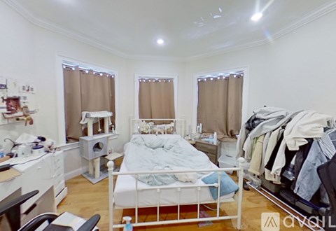 A bedroom with a bed, desk, and chair.