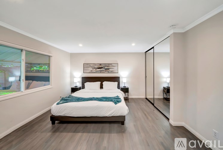 A bedroom with a large bed and a mirror on the wall.