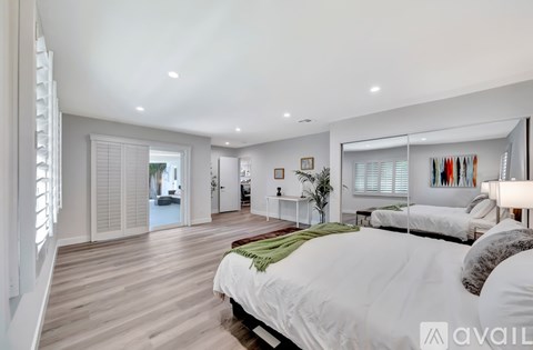 A bedroom with a large bed and a view of a hallway.