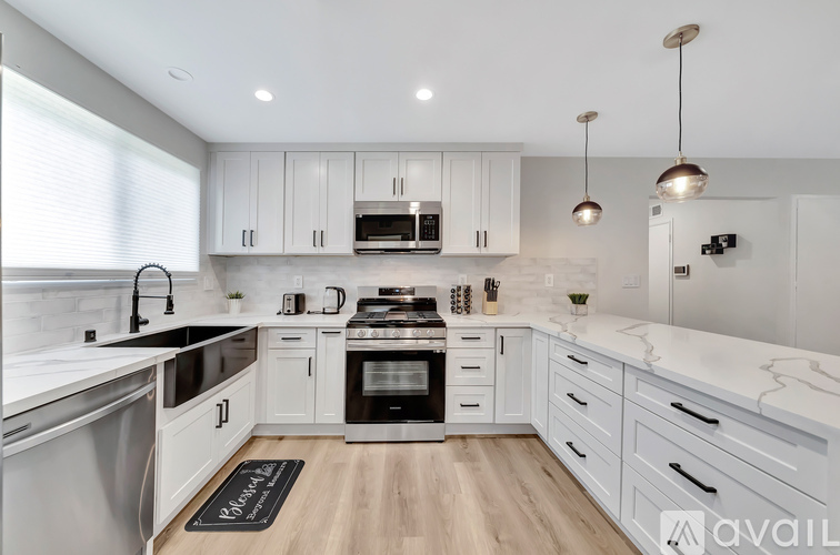 A modern kitchen with white cabinets and stainless steel appliances.
