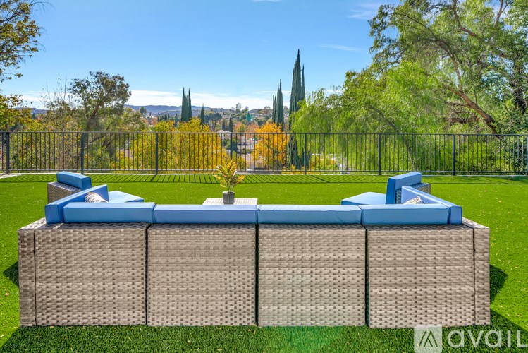 A large outdoor furniture set is set up on a lawn.