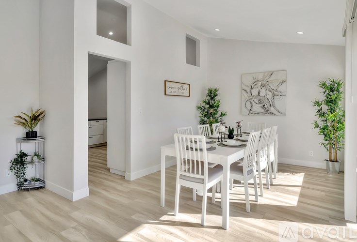 A white dining room with a table set for four.