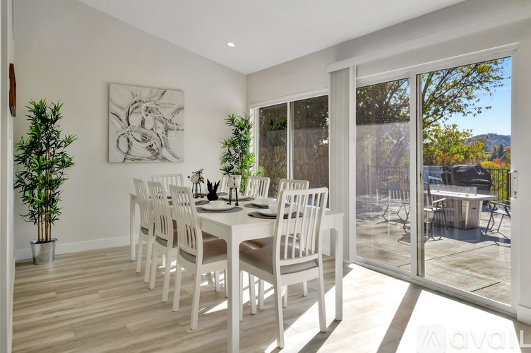 A dining room with a white table and chairs.