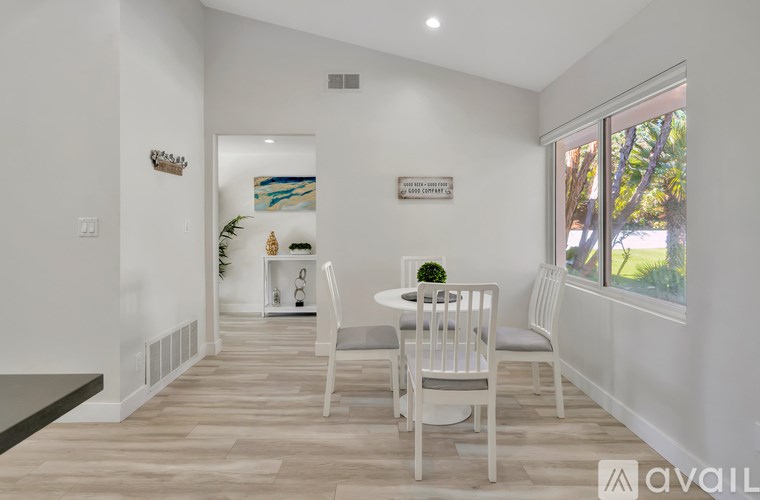 A dining room with a white table and chairs.