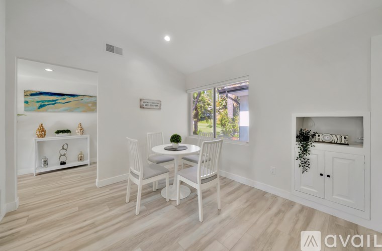 A dining room with a white table and chairs.
