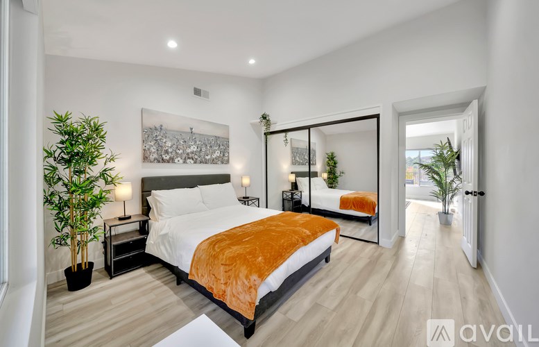 A bedroom with a large bed and a mirror on the wall.