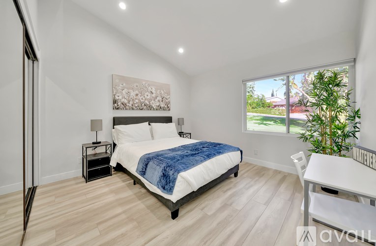 A bedroom with a large bed and a painting on the wall.