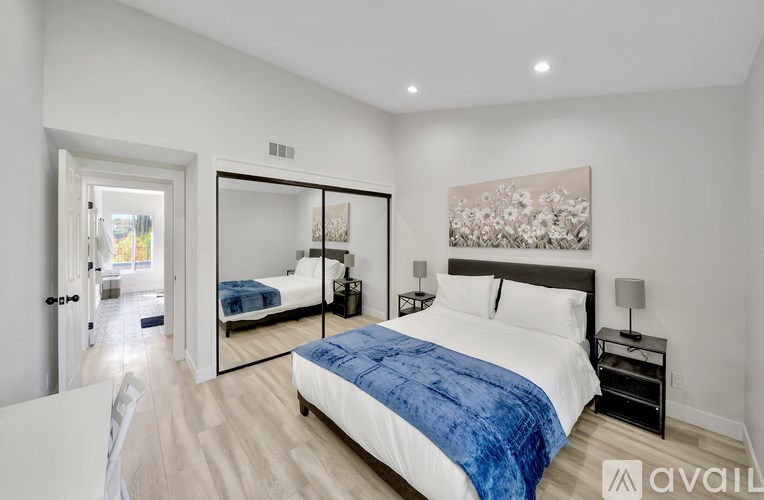 A bedroom with a large bed and a painting on the wall.