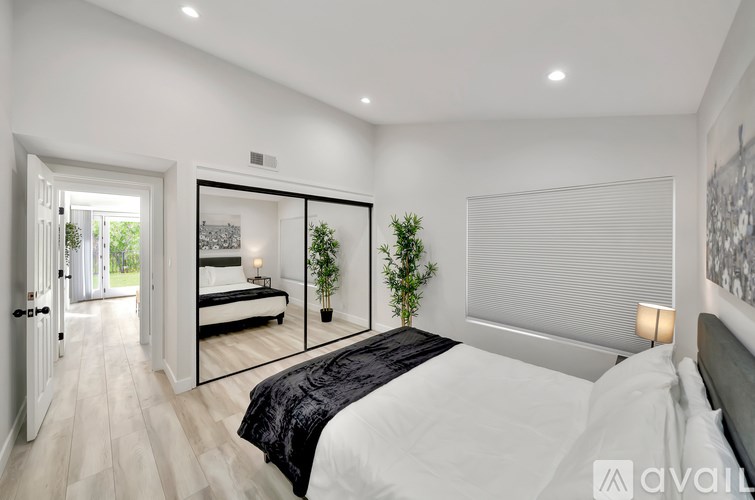 A bedroom with a large bed and a mirror on the wall.