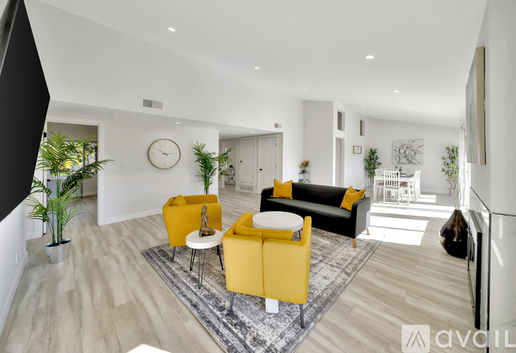 A living room with a yellow sofa and a white coffee table.