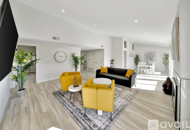 A living room with a yellow sofa and a white coffee table.