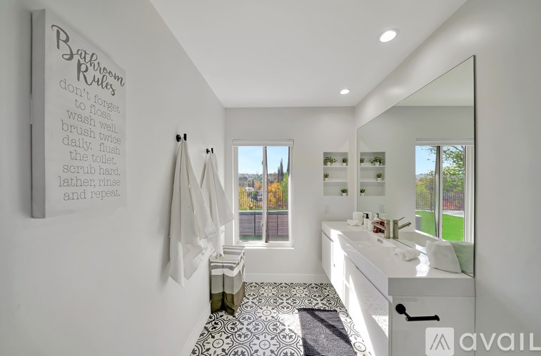 A bathroom with a mirror, sink, and a sign on the wall.