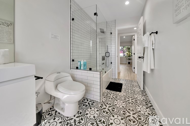 A bathroom with a toilet, sink, and a tiled floor.