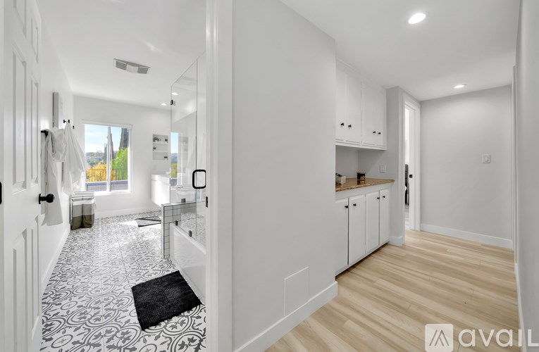A hallway with a black and white patterned rug on the floor.