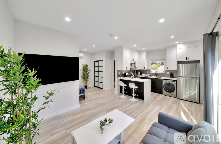 A modern kitchen with a dining area and a living room.
