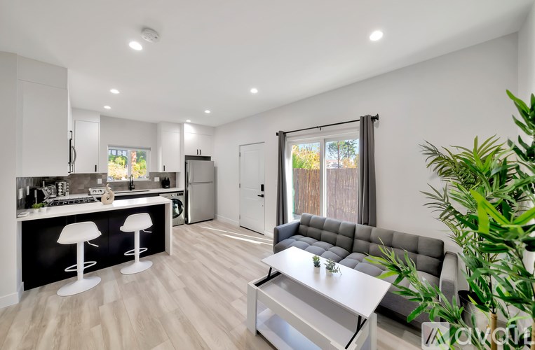 A modern kitchen with a bar area and a seating area.