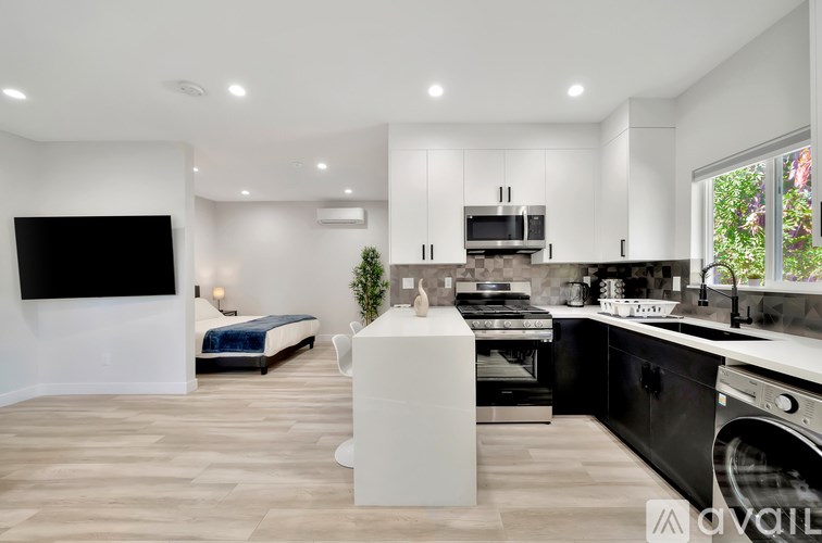 A modern kitchen with a black countertop and a white cabinet.