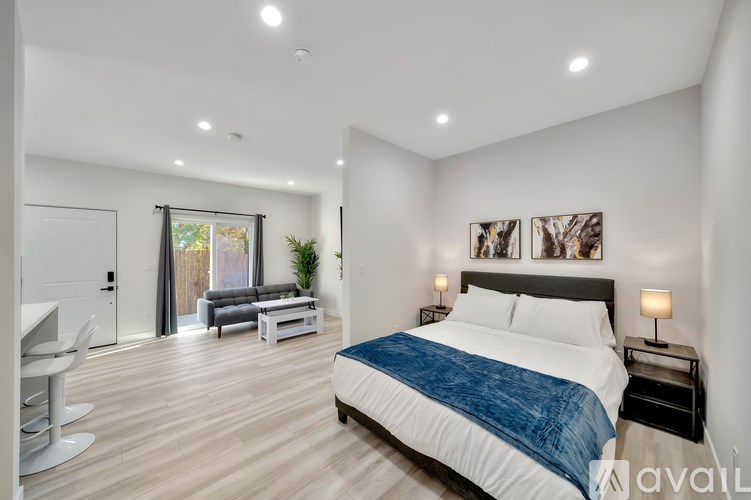 A bedroom with a large bed and a couch in the background.
