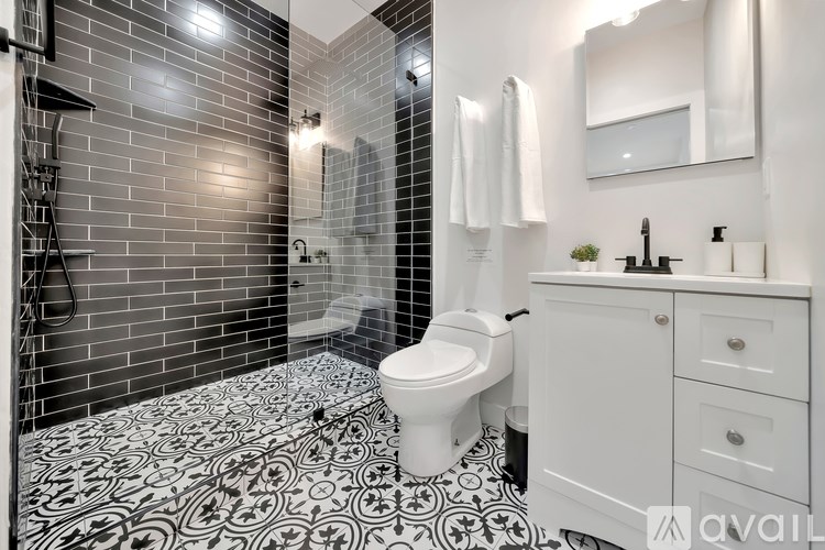 A bathroom with a black and white floor and a white toilet.