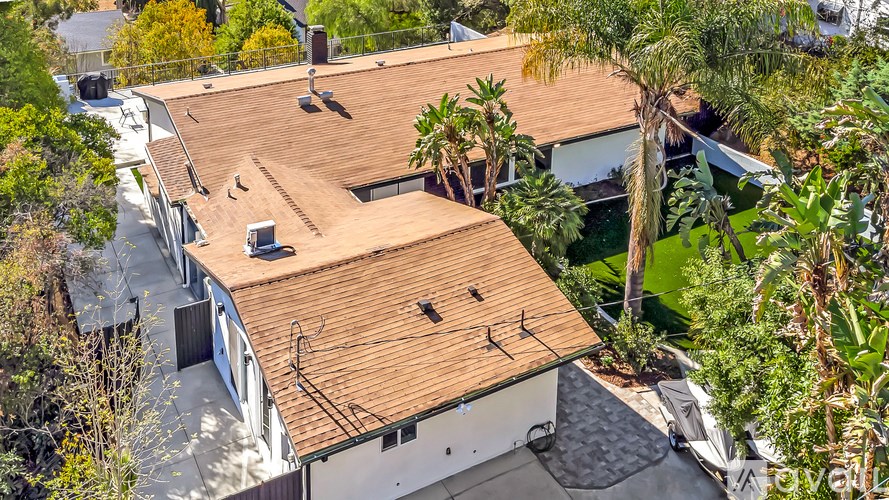 A house with a brown roof surrounded by trees.