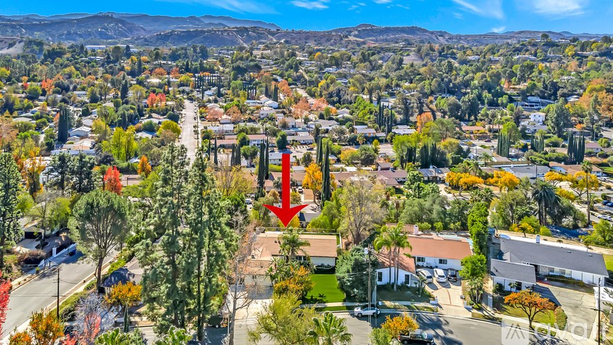 A red arrow points to a house in a suburban neighborhood.