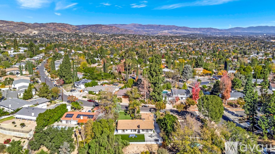 A bird's eye view of a residential neighborhood with houses and trees.