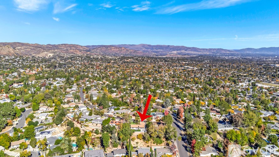A red arrow points to a house in a suburban neighborhood.