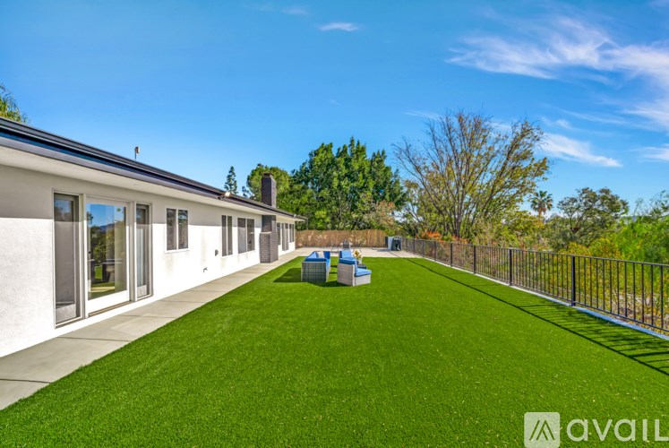 A house with a green lawn and a blue sky in the background.