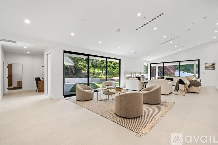 A spacious living room with a large window and a view of the outdoors.