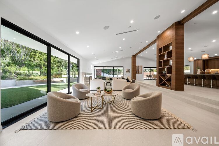 A modern living room with a large window and a view of the garden.