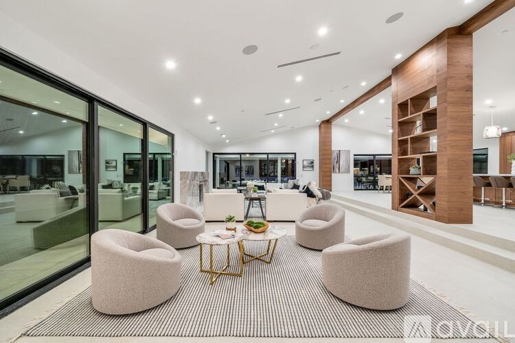 A modern living room with a glass wall and a coffee table.