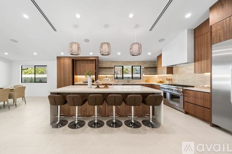 A modern kitchen with a center island and stools.