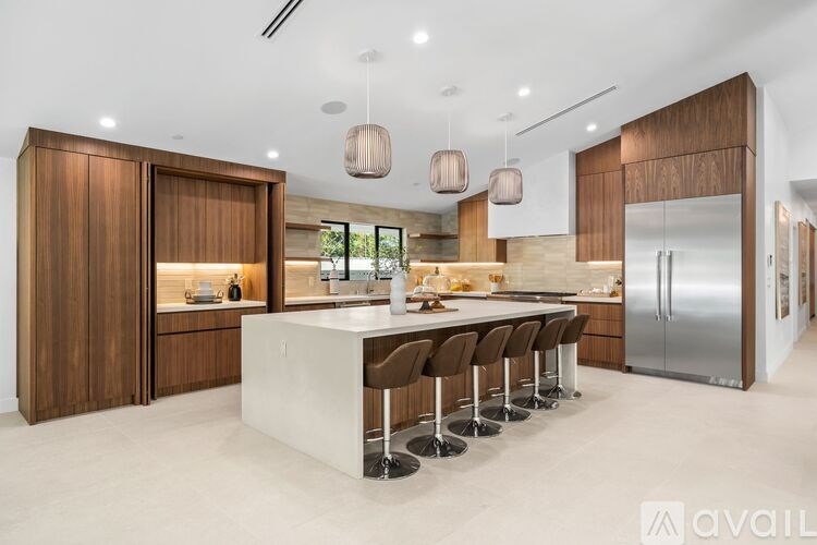 A modern kitchen with a central island and wooden cabinets.