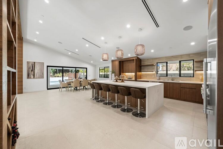 A modern kitchen with a bar area and a dining table.