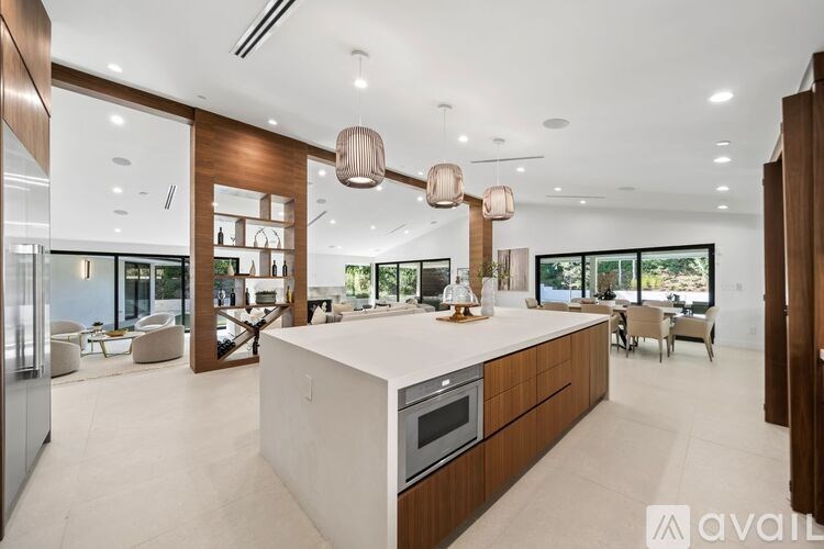 A modern kitchen with a large island and pendant lights.