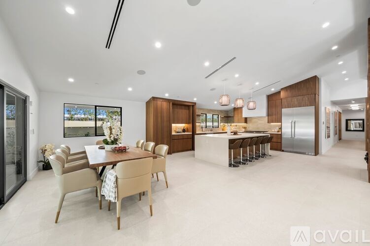 A modern kitchen with a dining table set for six.