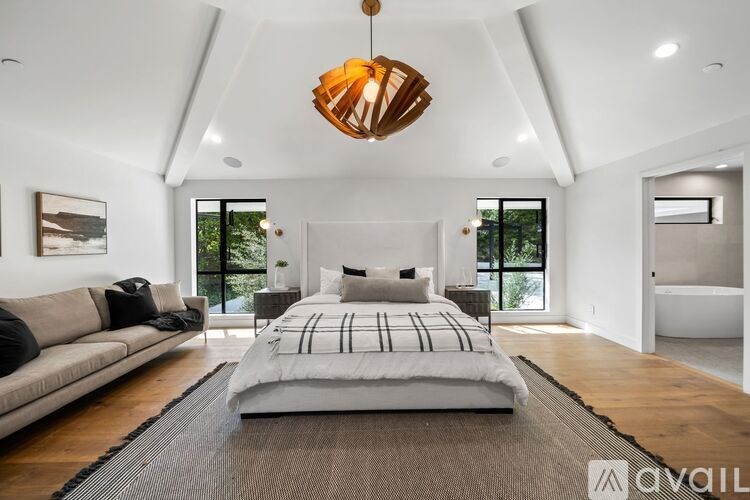 A modern bedroom with a large bed and a couch.