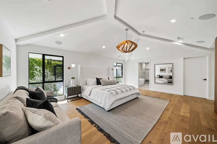 A modern bedroom with a large bed and a couch.