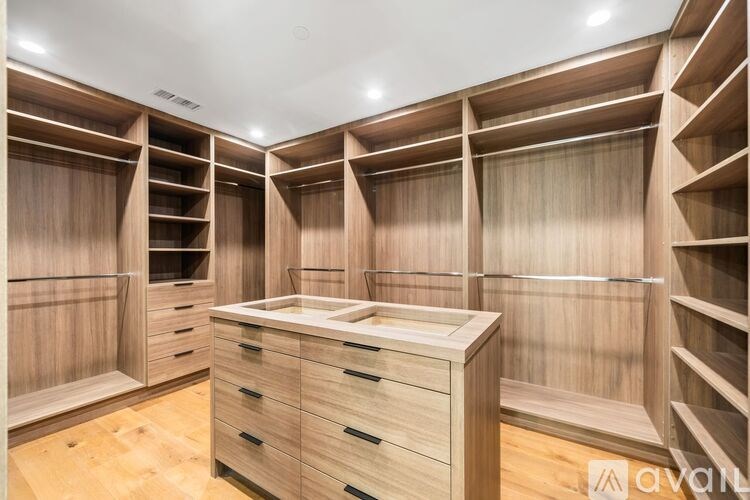 A walk-in closet with wooden shelves and drawers.