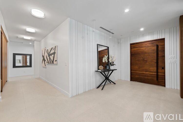 A room with a white wall and a wooden door.