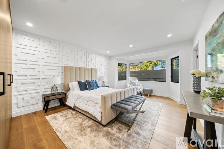 A bedroom with a large bed and a bench in front of it.